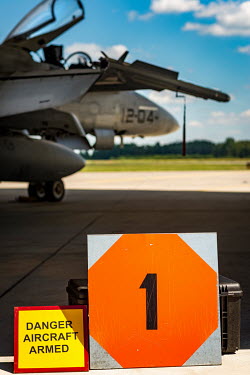 A sign, near a Spanish F18 fighter parked at a NATO airbase, reads: 'Danger aircraft armed'.