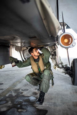 A Spanish pilot checking his F18 fighter aircraft before a flight from a NATO airbase.