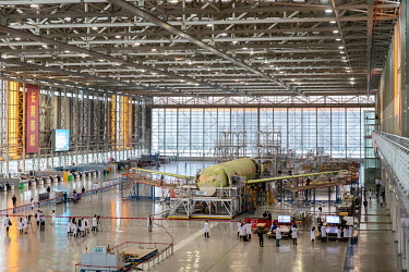 Technicians and visitors stand around a Commercial Aircraft Corp. of China Ltd. (Comac) C919 as it is assembled at the Comac Shanghai Research and Development Center.