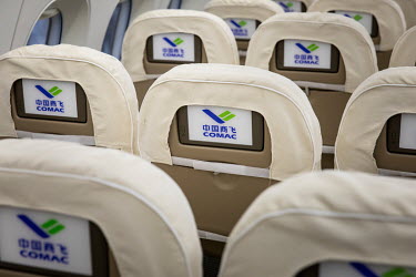 Entertainment screens sit in the back of passenger seats inside of a mock up of the Commercial Aircraft Corp. of China Ltd. (Comac) C919 aircraft at the Comac Shanghai Research and Development Center.