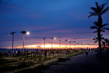 Chinese supplied solar lights illuminate exercise machines on the beach.