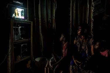 A family watch the television at their home where the power is supplied from a photovoltaic solar array.
