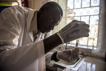 Laboratory technician Denis Bongoyinge prepares a sample for testing at the RHU clinic.