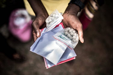 Akello Monica (25) a commercial sex worker, displays drugs dispensed by the RHU clinic.