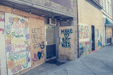 Grafitti extolling peace on boarded over shop fronts following protests, some violent, against the police shooting of Jacob Blake.