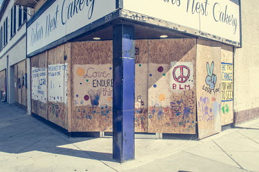 Graffiti painted on a boarded over business following protests, some violent, against the police shooting of Jacob Blake.