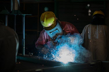 Workers apply welds on end frames used for shipping containers at the Singamas Container Holdings factory. As part of their pledge to cut emissions by 70 percent by the end of 2017, and in response to...