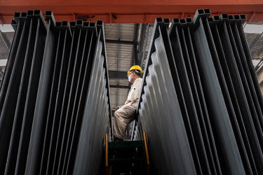 A worker sits on panels used for the manufacture of shipping containers in the welding shop at the Singamas Container Holdings factory. As part of their pledge to cut emissions by 70 percent by the en...