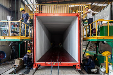 Workers assemble a shipping container at the Singamas Container Holdings factory. As part of their pledge to cut emissions by 70 percent by the end of 2017, and in response to the Chinese government's...