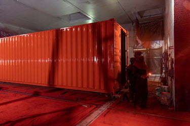 Workers operate in the paint shop of the Singamas Container Holdings factory. As part of their pledge to cut emissions by 70 percent by the end of 2017, and in response to the Chinese government's pla...