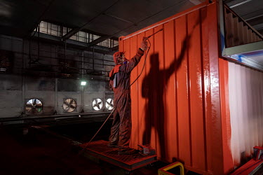 Workers operate in the paint shop of the Singamas Container Holdings factory. As part of their pledge to cut emissions by 70 percent by the end of 2017, and in response to the Chinese government's pla...