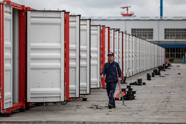 A worker walking past a row of shipping containers at the Singamas Container Holdings factory. As part of their pledge to cut emissions by 70 percent by the end of 2017, and in response to the Chinese...