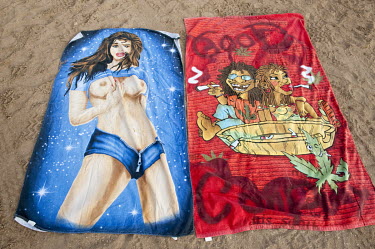 Towels on a beach, featuring a partially clothed woman and a couple smoking joints.
