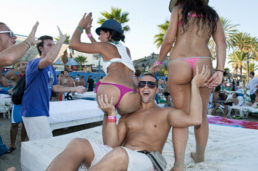 A man gropestwo women during a party at the Bora Bora open air disco on the Playa Den Bossa beach Eivissa.