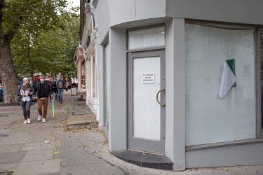 People walk past a business in Hampstead that has closed down as the British economy sinks into recession due to the coronavirus pandemic.