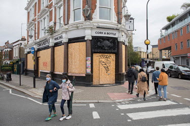 Pedestrians pass The Cork & Bottle Pub in Hampstead, a business that has closed down as the British economy sinks into recession due to the coronavirus pandemic.