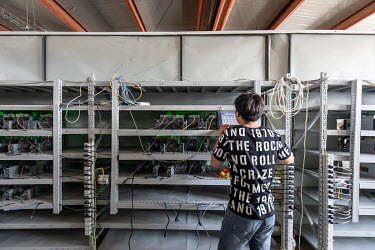 A technician inspects bitcoin mining computers at a warehouse mining facility operated by Bitmain Technologies Ltd. Bitmain is one of the leading producers of Bitcoin-mining equipment and also runs An...