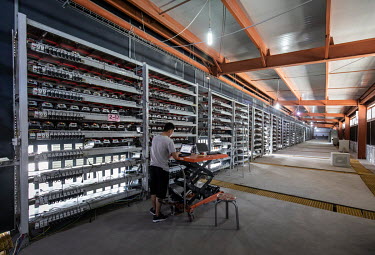 A technician inspects bitcoin mining computers at a warehouse mining facility operated by Bitmain Technologies Ltd. Bitmain is one of the leading producers of Bitcoin-mining equipment and also runs An...