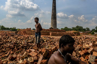 Suman Das (13) waits with his father Bapi Das at a brick factory in North 24 Parganas. Suman used to makes bricks in a factory after school, but now he has left school since the coronavirus lockdown t...