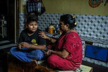 Singh (13) with his mother in a one of the brothels in Chawri Bazar where she is a sex worker. He is from Rajastan and has finished his first day at a tea stall where he is working as schools have bee...
