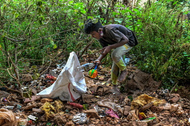 Rahul (11) walks bare foot over piles of rubble as he collects plastic with his father to sell to recyclers on the outskirts of the city.  Rahul was doing well at school until the coronavirus lockdown...