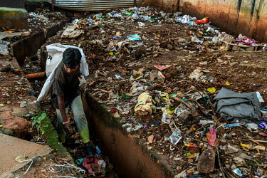Rahul (11) walks in a drain as he collects plastic with his father to sell to recyclers on the outskirts of the city.  Rahul was doing well at school until the coronavirus lockdown closed schools and...