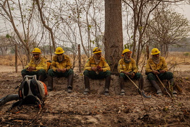 Exhusted members of the Brazilian Institute for the Environment and Renewable Natural Resources (IBAMA) fire brigade rest after more than 12 hours spent trying to control a forest fire burning on the...
