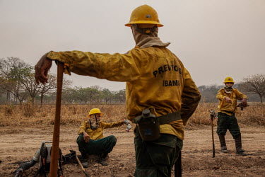 Exhusted members of the Brazilian Institute for the Environment and Renewable Natural Resources (IBAMA) fire brigade rest after more than 12 hours spent trying to control a forest fire burning on the...