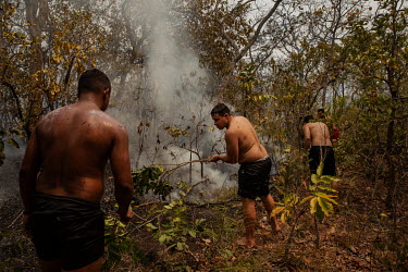 A group of passing tourists try to control a spot fire that has broken out near the Mutum River, in rural Santo Antonio Leverger, in the Pantanal.  Since the beginning of 2020, the Pantanal has been...