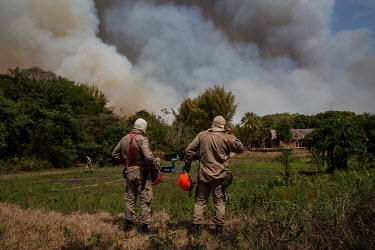 Firefighters try to protect a house on the banks of the Cuiaba River that is surrounded by smoke and flames from one of the many wildfires sweeping through the Pantanal.  Since the beginning of 2020...