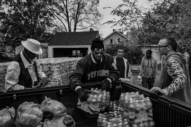 Volunteers at a neighborhood church destribute mineral water to residents. Since 2014, when the acid waters of the Flint River began to be used to supply the city, there has been lead contamination du...