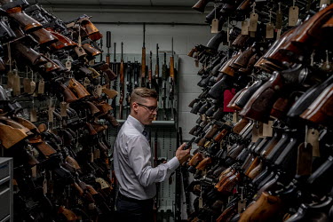 Gregg Taylor surrounded by weapons in the gun collection room at the National Ballistics Intelligence Service.