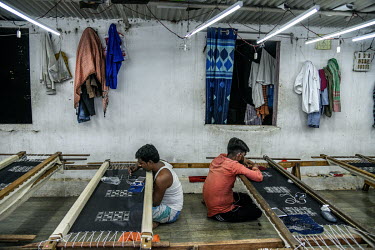 Labourers at an embroidery subcontractors attach sequins and beads to fabrics in a small factory housed in a residential block. The factory does not adhere to the Indian government's Factory Act or em...