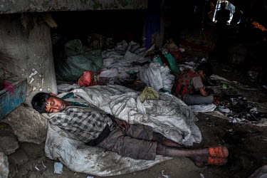 A homeless boy sleeps among piles of rubbish collected for recycling.  It is estimated that there are more than 600,000 street children living in Bangladesh, 75% of them live in the nation's capital,...