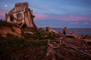 A boy walks through debris from homes destroyed by marine erosion in Praia do Leste in Sao Paulo state.