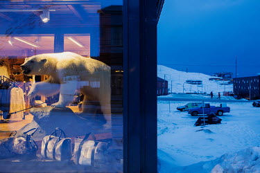 A stuffed polar bear on display in a shop selling clothes and other items, some made from animal skins. Temperatures in this region are warming faster than anywhere else on the planet, rising at least...