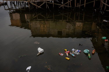 Discarded waste floats beneath stilt houses in the Mangue Seco slum.