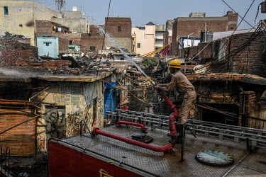 Delhi Fire Brigade personal douse the a fire at the Gokulpuri Tyre market. When rival groups, largely split between Hindus and Muslims, began protesting for and against the new Citizenship Amendment A...