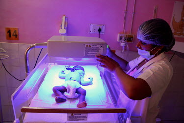 A health worker moves an ultra violet (UV) light over a premature baby who is undergoing treatment in the Phototherapy Ward at the Virangna Avanti Bai District Women's Hospital.