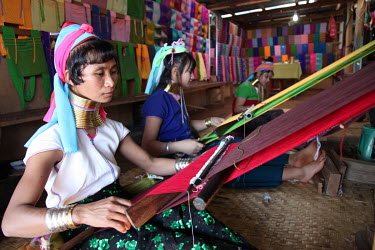 Women from the Kayah (Red Karen, Padaung) ethnic group weaving silk scarfs on hand looms.