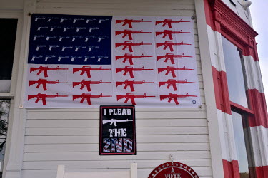 A flag decorated with images of guns display outside the home (known locally as 'Trump House') of President Donald Trump supporter Leslie Rossi.