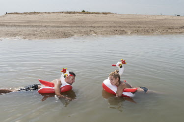 A couple float on a pair of novelty inflatable swans in the sea in Barreiro, once an industrial town that was the home of Companhia Uniao Fabril (CUF) which, from the 1930s until 1974, was one of Port...