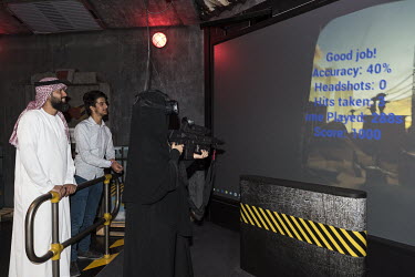 A veiled woman takes her turn with the googles and gun while playing a 3D game at Hub Zero, an immersive entertainment hub in the City Walk shopping mall.