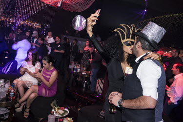 A woman takes a selfie as she kisses a man in a nightclub on New Year's Eve .