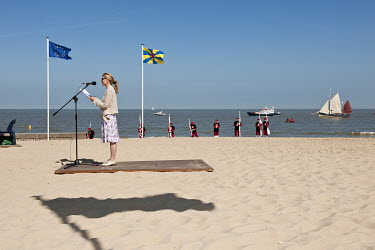 A woman gives a speech during a ceremony for the 'Blessing of the North Sea', when a large crucifix is carried from the water and paraded around town in a procession.