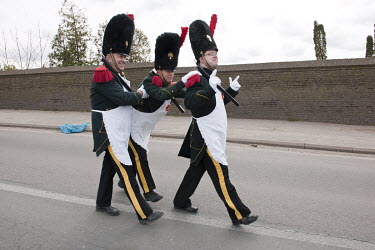 Three drunk men in historical military uniforms take part in A Catholic procession celebrating Saint Veronus.