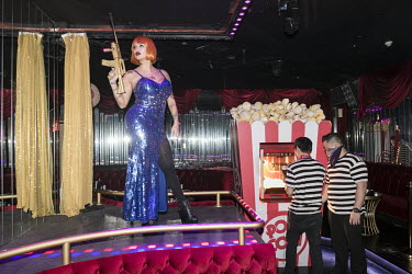 A nightclub dancer holding a novelty golden machine gun at the Cirque Le Soir nightclub.
