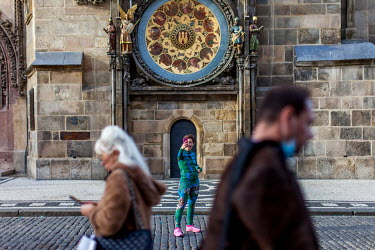 A female runner takes a selfie in front of the Astronomical clock in the Old Town Square. As of 21 October 2020 it is manditory for people to wear face masks both inside and out except while doing phy...