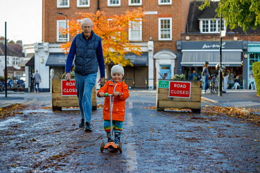 An elderly couple walks with a child on a road closed to motorised traffic in Dulwich.