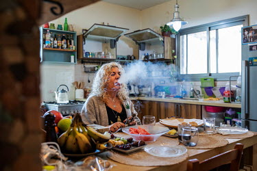 Hagit Yagoda, a medical cannabis activist, who uses the drug to help treat a cancer, smoking the medicinal cannabis using a water pipe in the kitchen of her home.